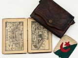 an old book with a leather cover and a small patch of cloth