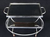 paire de plateaux de service en chrome et en verre montés sur roulettes, sur fond noir