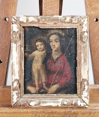 tableau représentant une femme tenant un enfant, posé sur un chevalet en bois