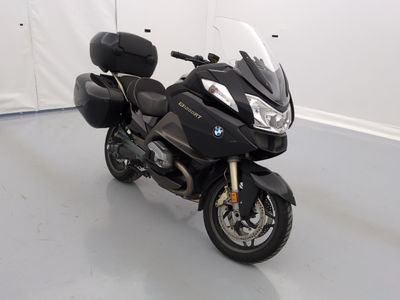 une moto noire garée dans une pièce aux murs blancs