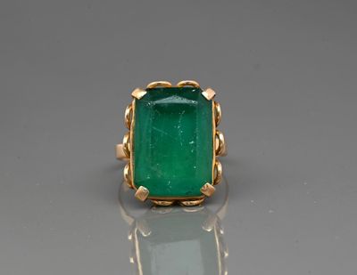a close up of a ring with a green stone in it