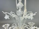 a glass chandelier with a bunch of flowers on it