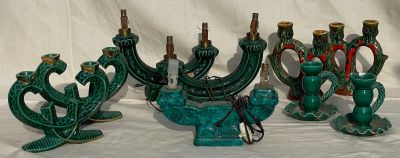 five green candles that are sitting on a table