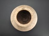a brown vase sitting on a black surface