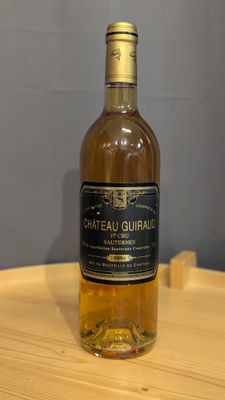 Des bouteilles de vin sont posées sur une table en bois dans une pièce.