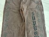 un pantalon en jean orné de strass sur les côtés, posé sur un lit