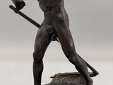 statue en bronze représentant un homme tenant une batte de baseball sur une base