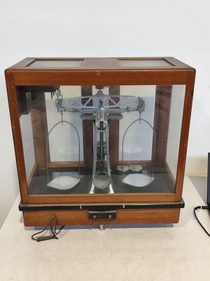une petite balance dans une vitrine posée sur une table