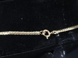 an image of a black hat with a gold chain on it