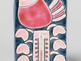 a ceramic thermometer with a bird on it