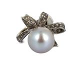 une image représentant une bague en perle blanche et diamants sur fond blanc