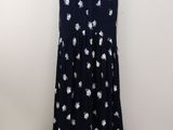 a black dress with white flowers is hanging on a hanger