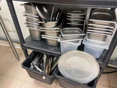 many pans and pans on a shelf in a kitchen