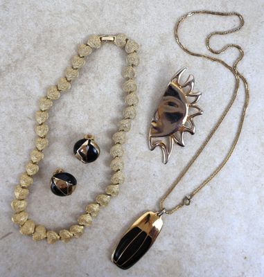 collier, bracelet et bague dorés et noirs, avec un pendentif en forme de soleil