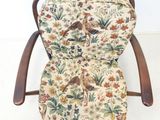 a wooden chair with a floral seat pad on it