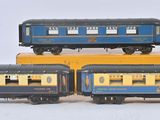 trois petits trains jouets empilés les uns sur les autres sur une surface blanche