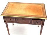 a small wooden table with three drawers on it