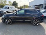 a black volkswagen suv parked in a parking lot next to other cars