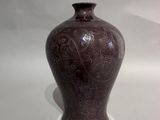 a brown vase that is sitting on a white surface