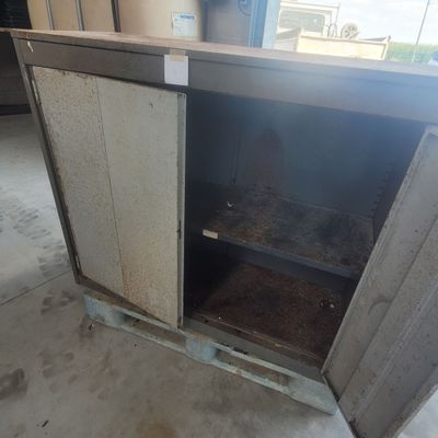 a metal cabinet with a door open in a garage