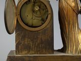 a statue of a lady holding a sword and a clock