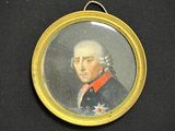 portrait d'un homme en uniforme militaire, dans un cadre doré, sur fond noir