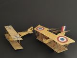 two wooden model airplanes sitting on a black surface