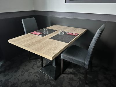 a table and chairs in a small room with a picture on the wall