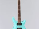 a blue electric guitar on a stand against a white background