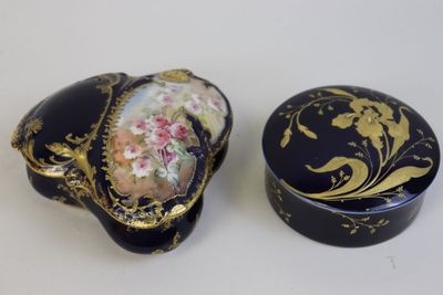 deux boîtes noires et dorées ornées de motifs floraux sur un fond blanc