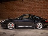 a black sports car parked in front of a brick wall