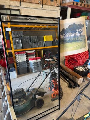 une photo d'un homme en train de réparer une tondeuse à gazon dans un garage