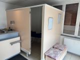 une petite chambre avec un lit et un lavabo