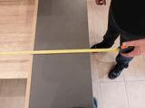 a man that is holding a measuring tape on the floor