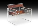 une chaise en cuir marron et chrome sur fond noir