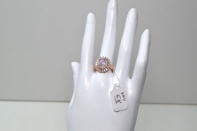 une main blanche à laquelle est fixée une bague et une étiquette