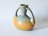 a small vase that is sitting on a white surface