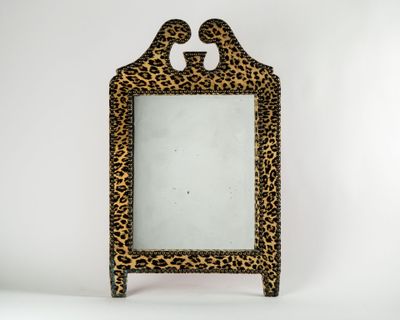 an animal print mirror with a wooden frame and a leopard print design