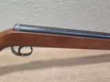 a close up of a rifle on a table with a wall in the background