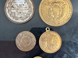 trois médailles d'or et d'argent exposées dans une vitrine