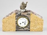 a small clock with a statue on top of it