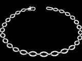 un gros plan d'un bracelet à chaîne argentée sur fond noir