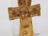 gold plated cross pendant on clear acrylic stand on white background