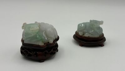 deux figurines en jade posées sur un socle en bois