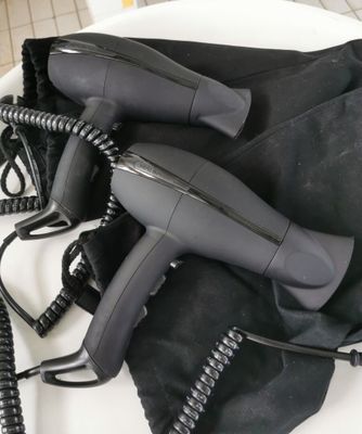 a black blow dryer sitting on top of a black bag