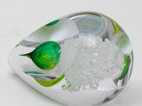a glass object with a green flower inside of it