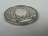 an image of a silver coin with a wreath on it