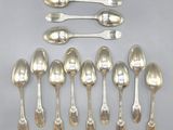 six silver spoons and two silver spoons on a table