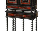 une armoire ancienne noire et rouge à deux tiroirs, posée sur un socle