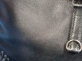 a close up of a black purse with fringes on it